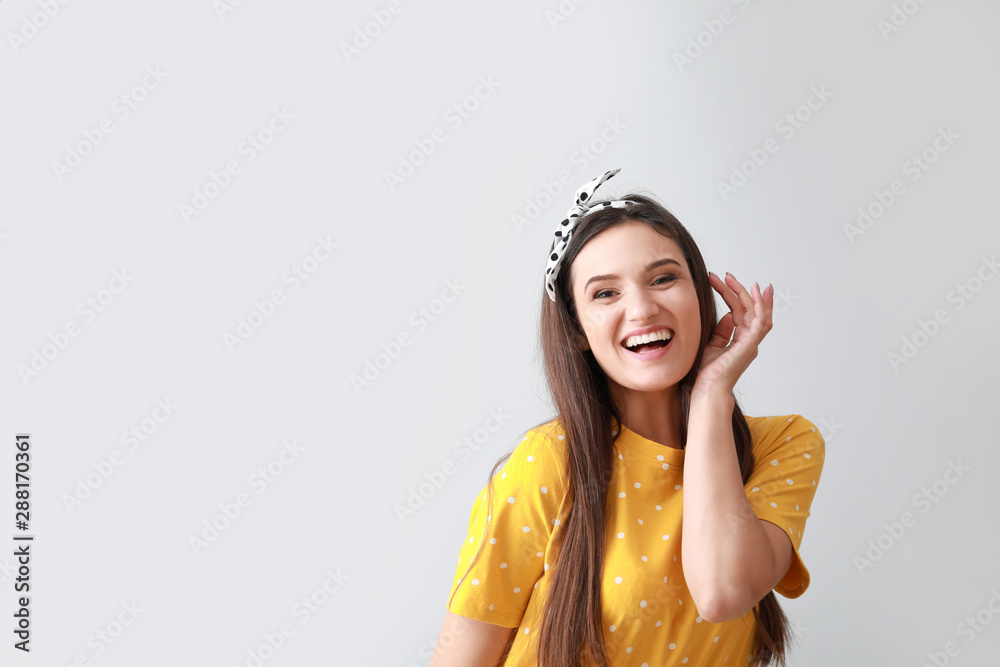 Portrait of happy young woman on grey background