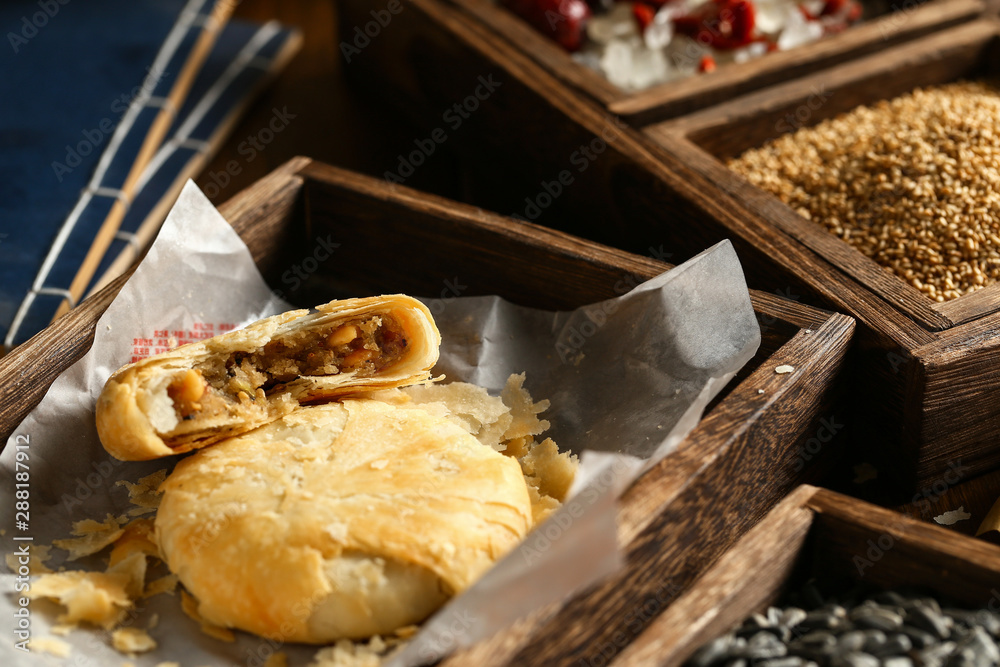 木桌上木箱里的脆皮月饼。中文翻译：五粒月饼