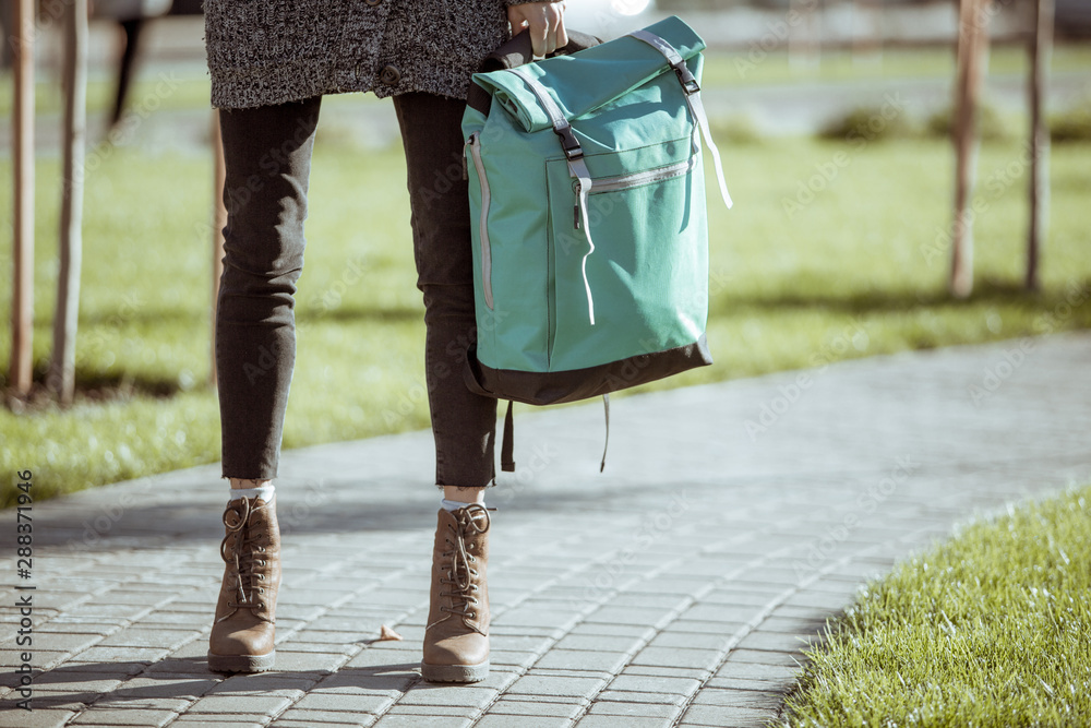 Lifestyle fashion portrait of young stylish hipster woman walking on the street