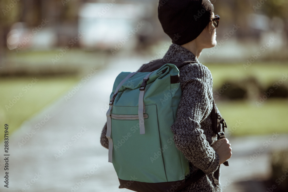 Lifestyle fashion portrait of young stylish hipster woman walking on the street