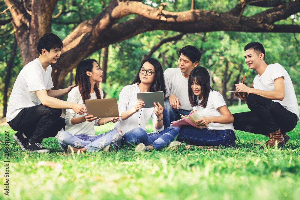 在大学或学校公园的小组项目中学习的年轻学生团队。快乐学习