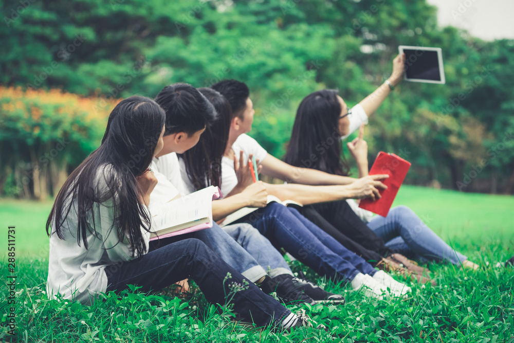 在大学或学校公园的小组项目中学习的年轻学生团队。快乐学习