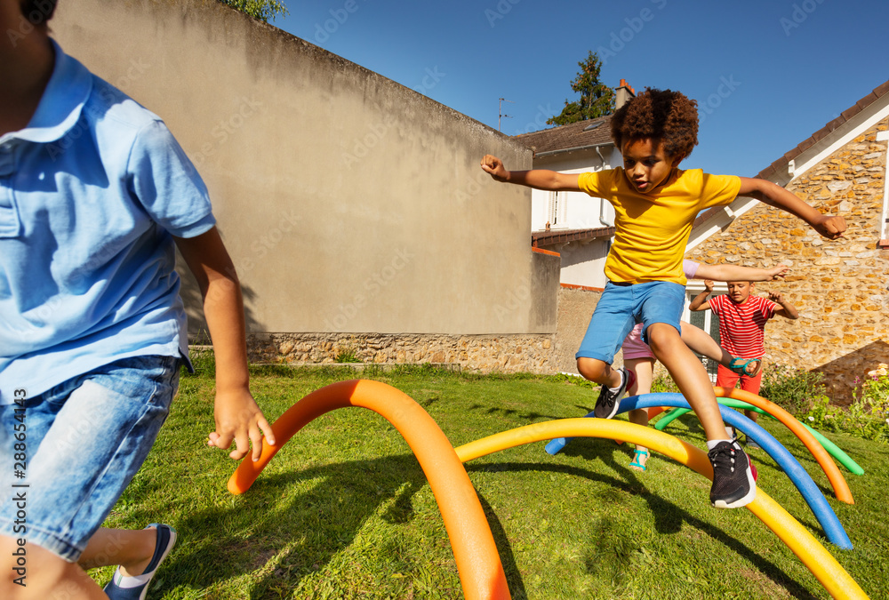 Race with obstacles many kids jump over barrier