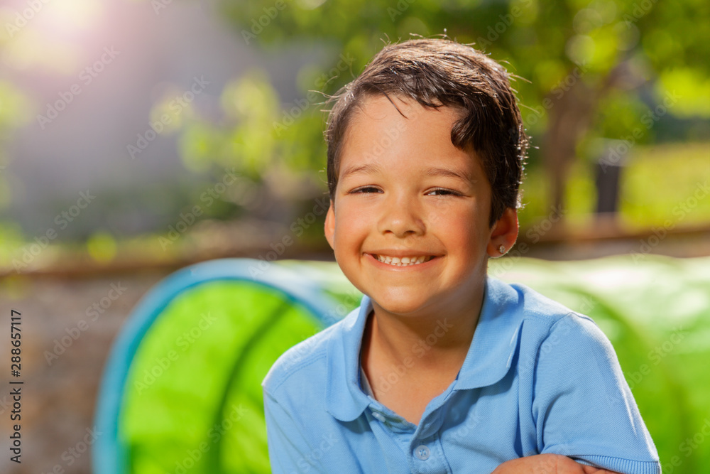 Summer day close portrait of a smiling cute boy