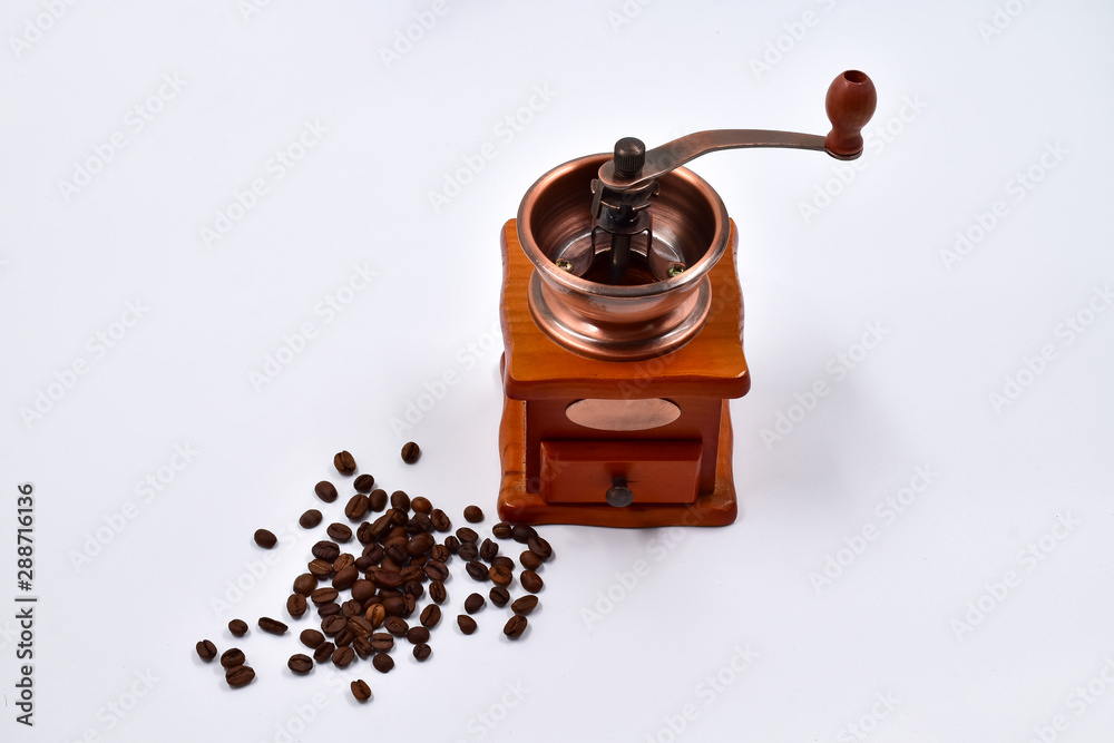 Coffee beans and manual coffee grinder on a white background