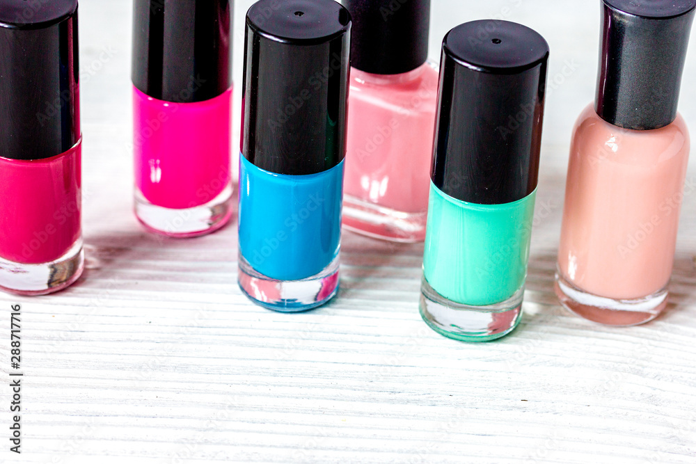 bottles of colored nail polish on wooden background