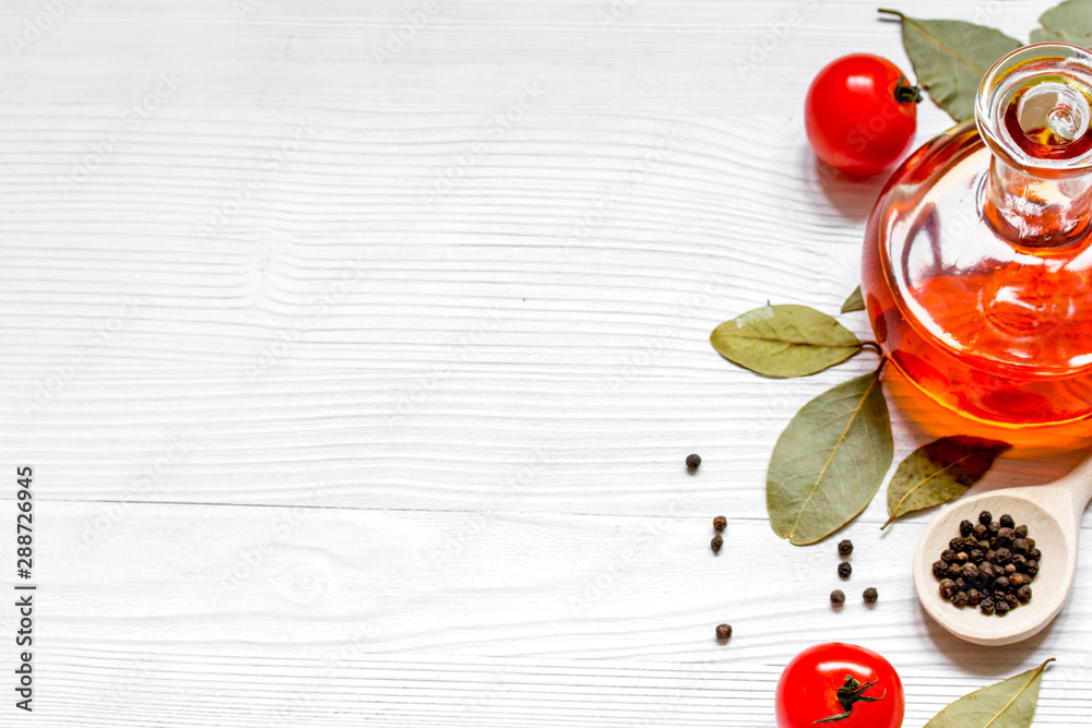 olive oil in jar on wooden background with spices