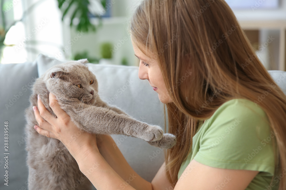 Beautiful woman with cute cat at home