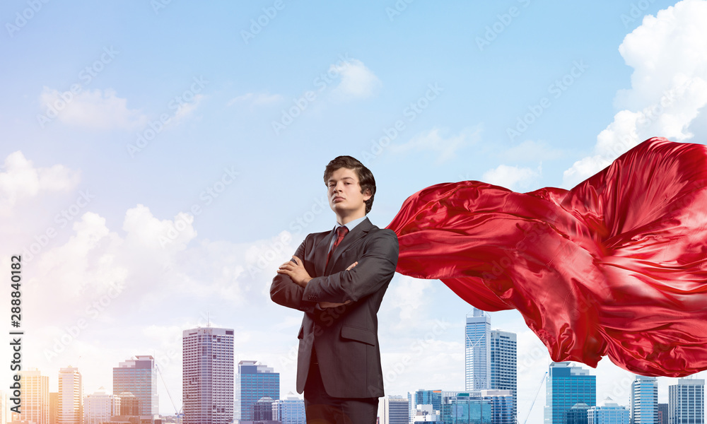 Concept of power and sucess with businessman superhero in big city