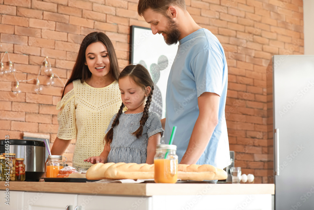 Young family with freshly baked buns in kitchen