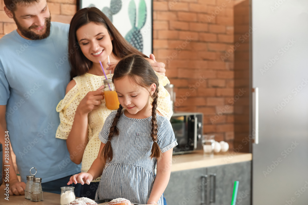 Young family with freshly baked buns in kitchen