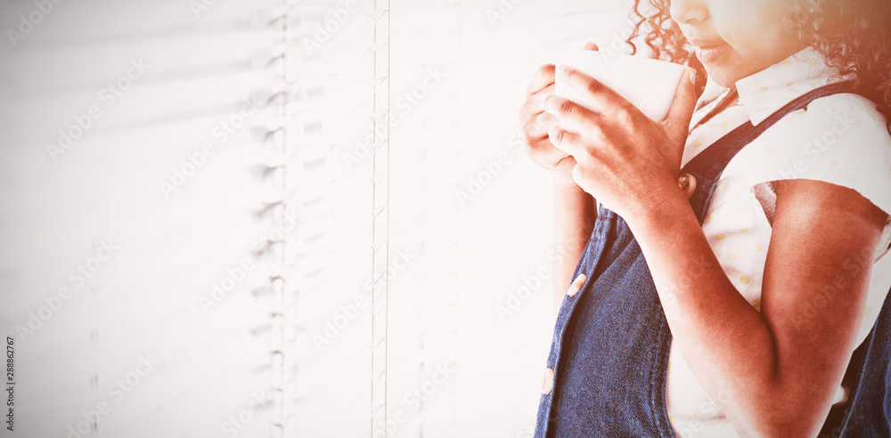 Thoughtful businesswoman with curly hair holding coffee cup