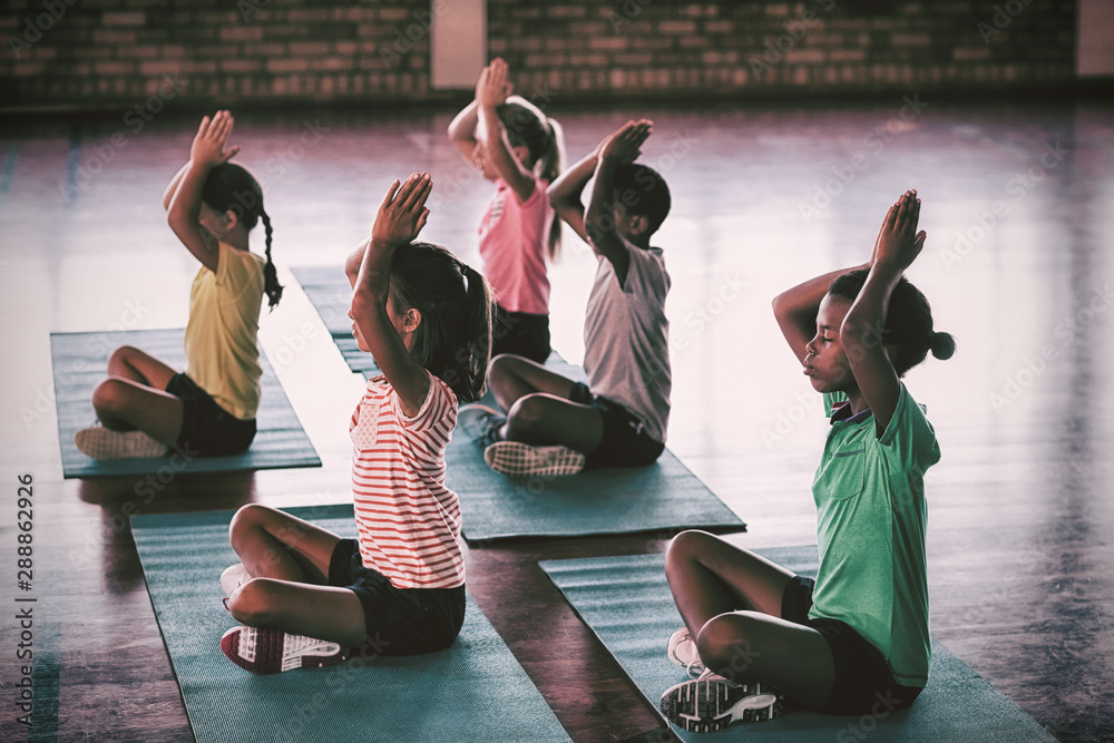 School kids meditating during yoga class