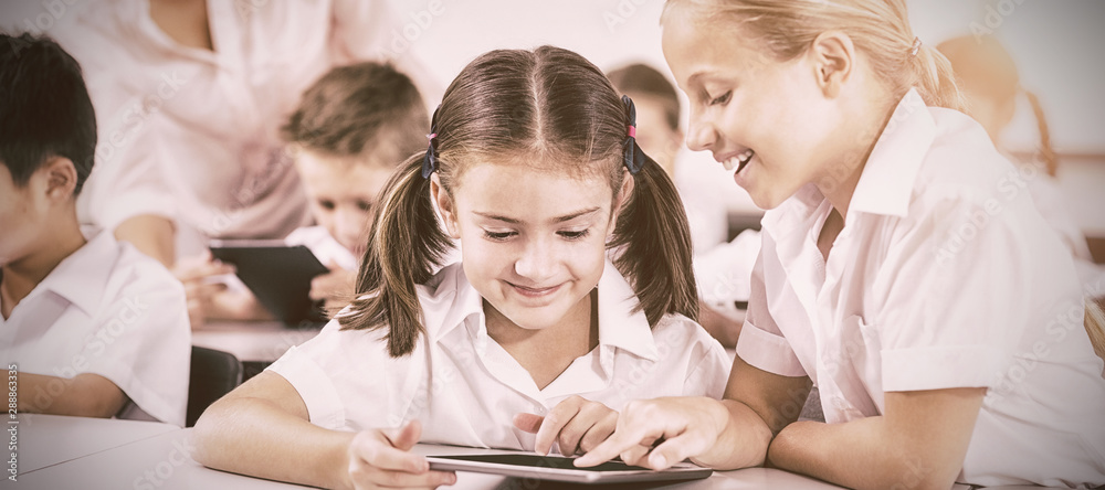 Children using digital tablets in classroom