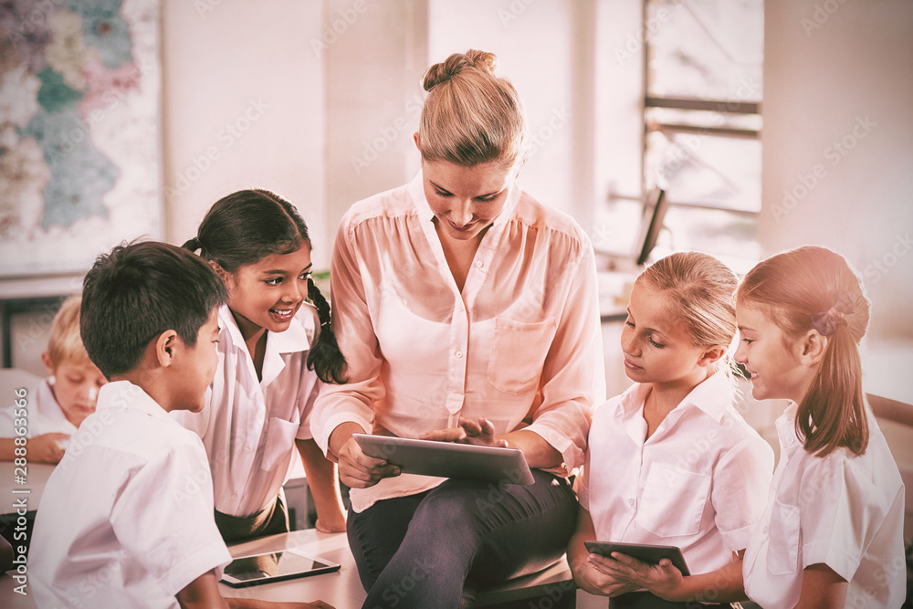 Teacher teaching kids on digital tablet