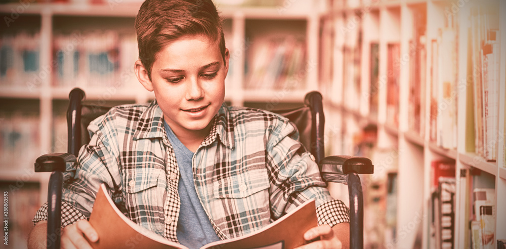 Disabled schoolboy reading book in library