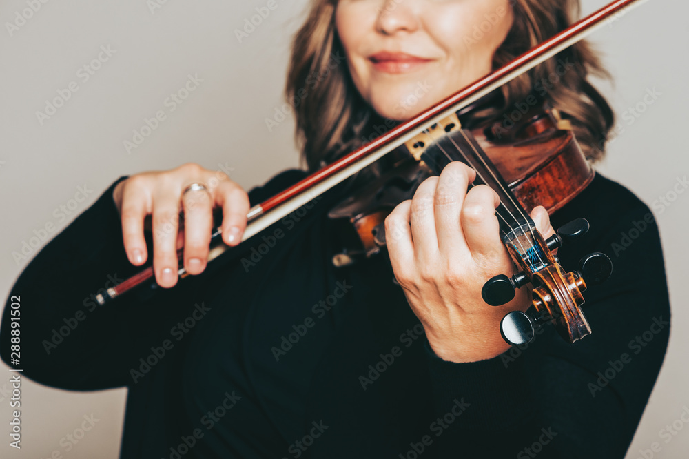 Studio close up portrait of beautiful woman with violin, white background