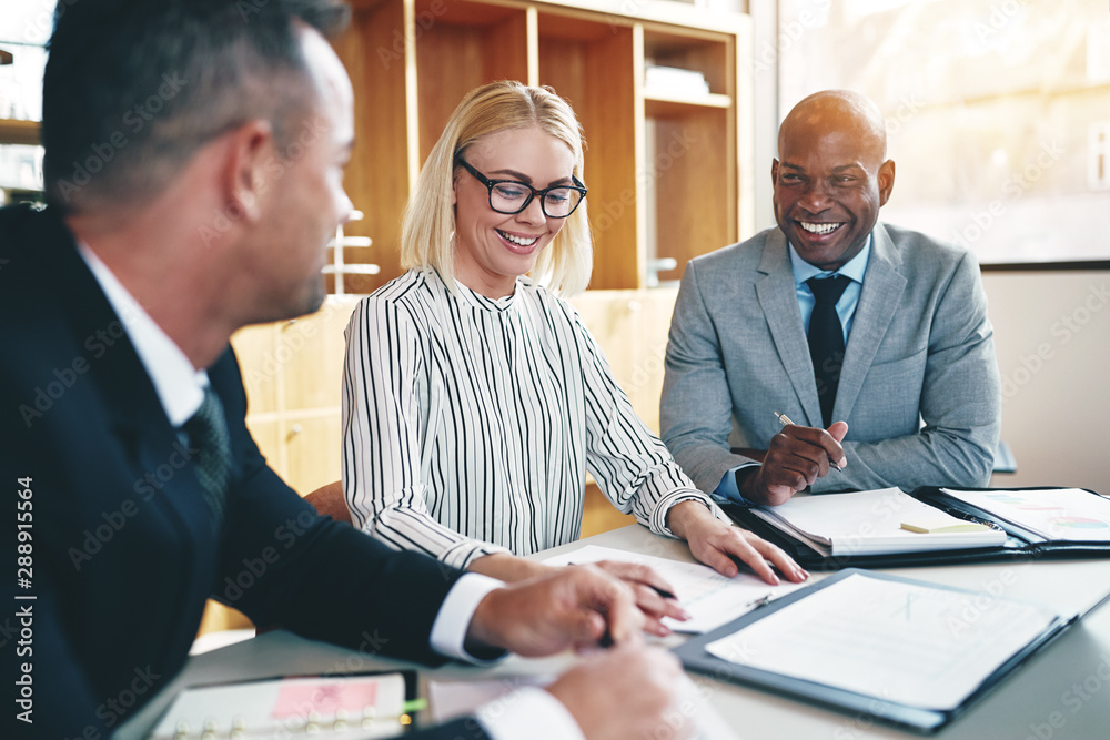 Diverse group of businesspeople laughing during an office meeting