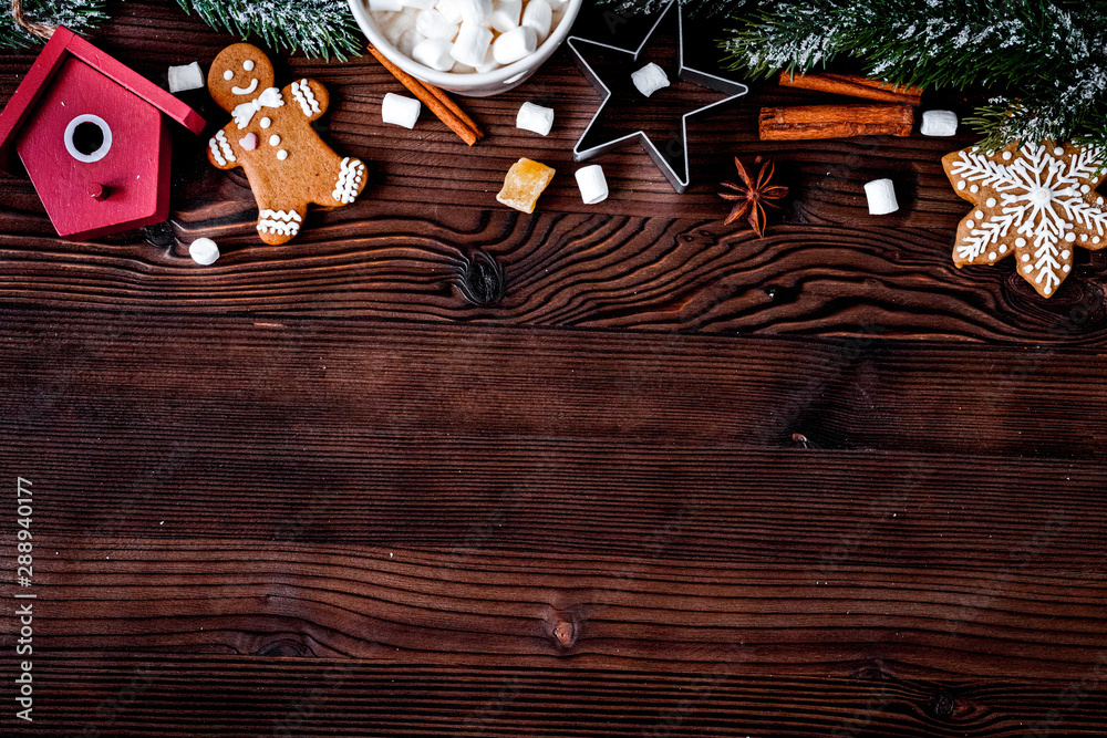 Christmas gingerbread, spruce branches on dark wooden background top view