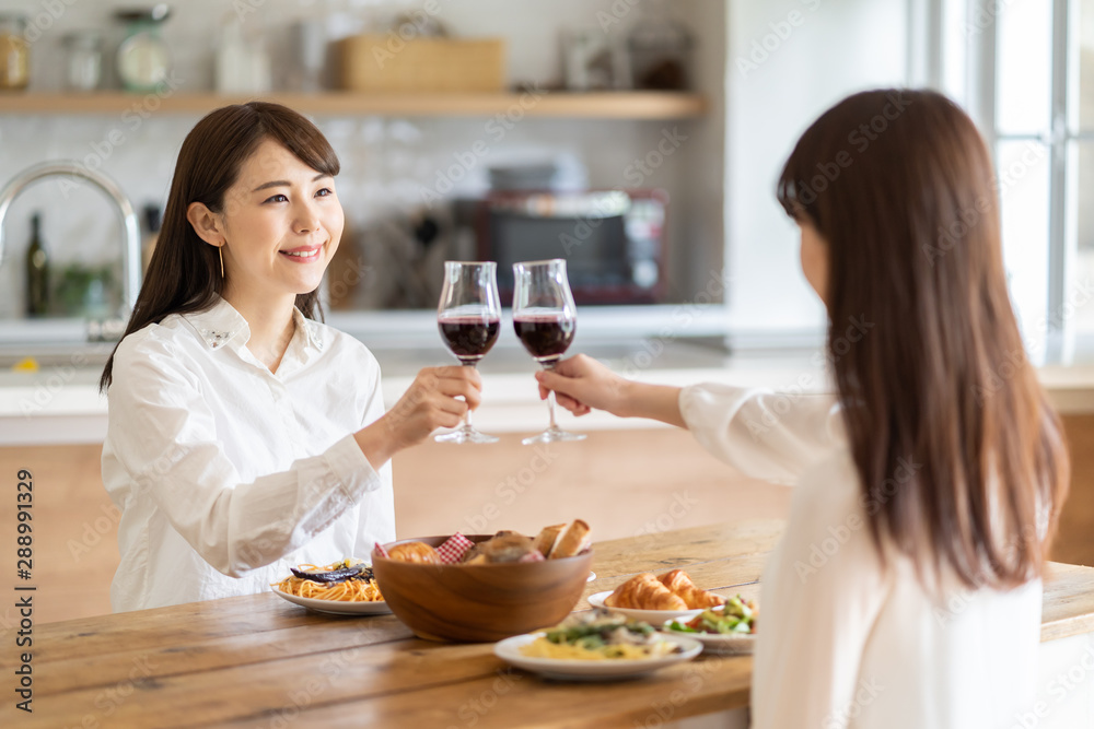 魅力四射的亚洲女性在用餐时喝着兰契