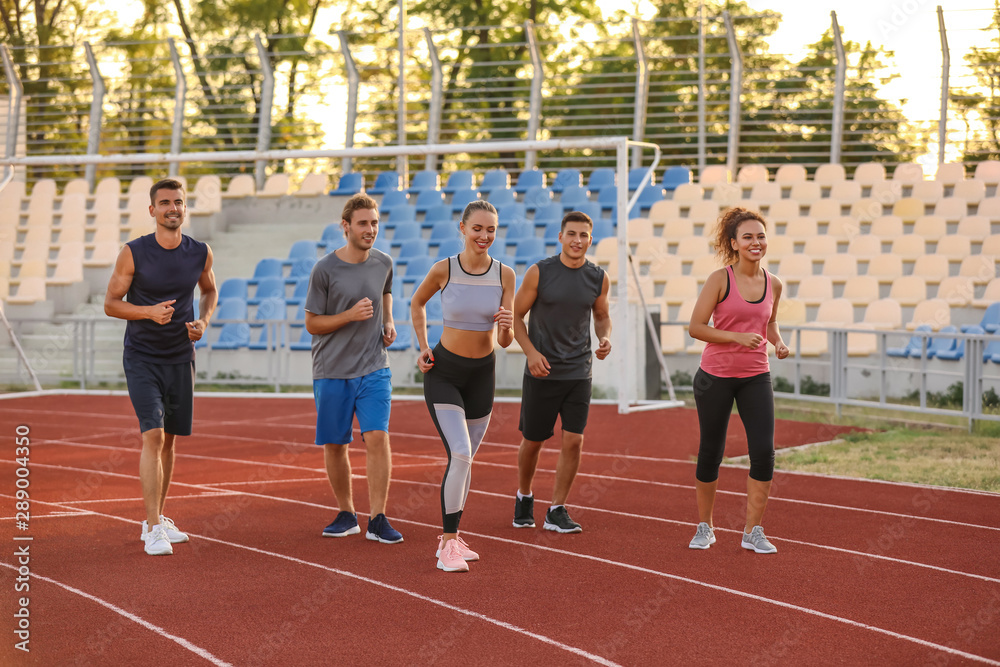 Sporty young people running at the stadium