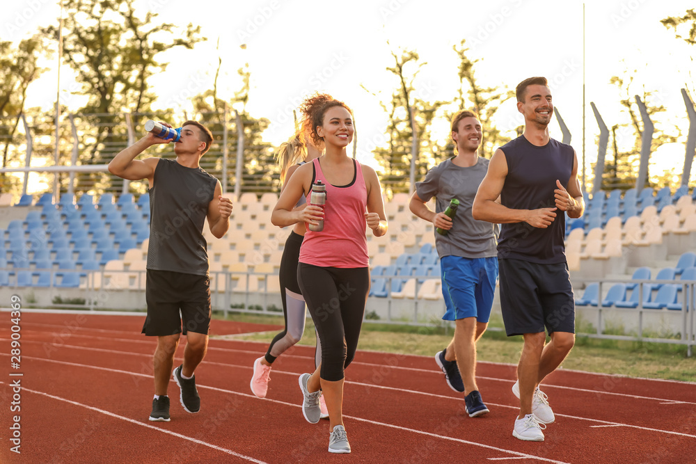 Sporty young people running at the stadium