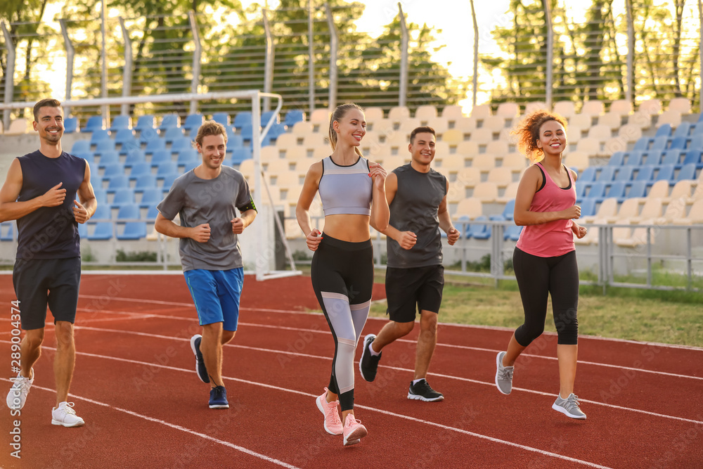 Sporty young people running at the stadium