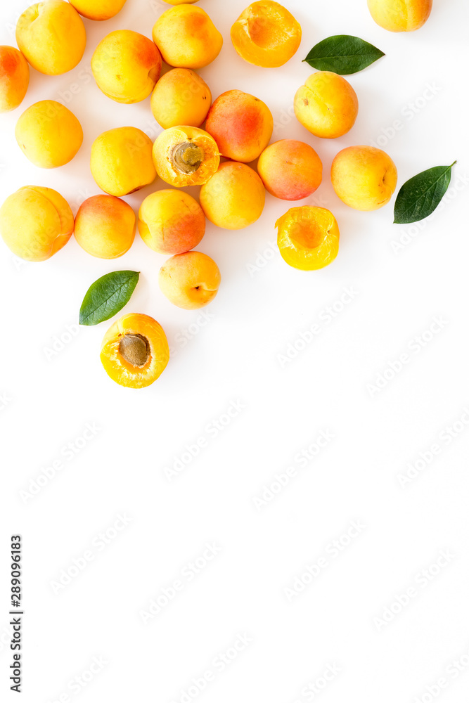 Fruit background with apricots and leaves on white background top view space for text