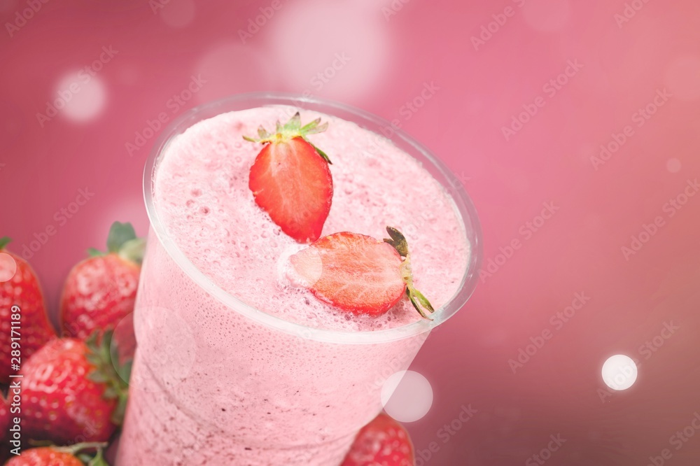 Glass of strawberry smoothie on wooden table