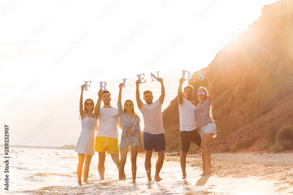 度假胜地海滩上的年轻人用字母组成的单词FRIENDS