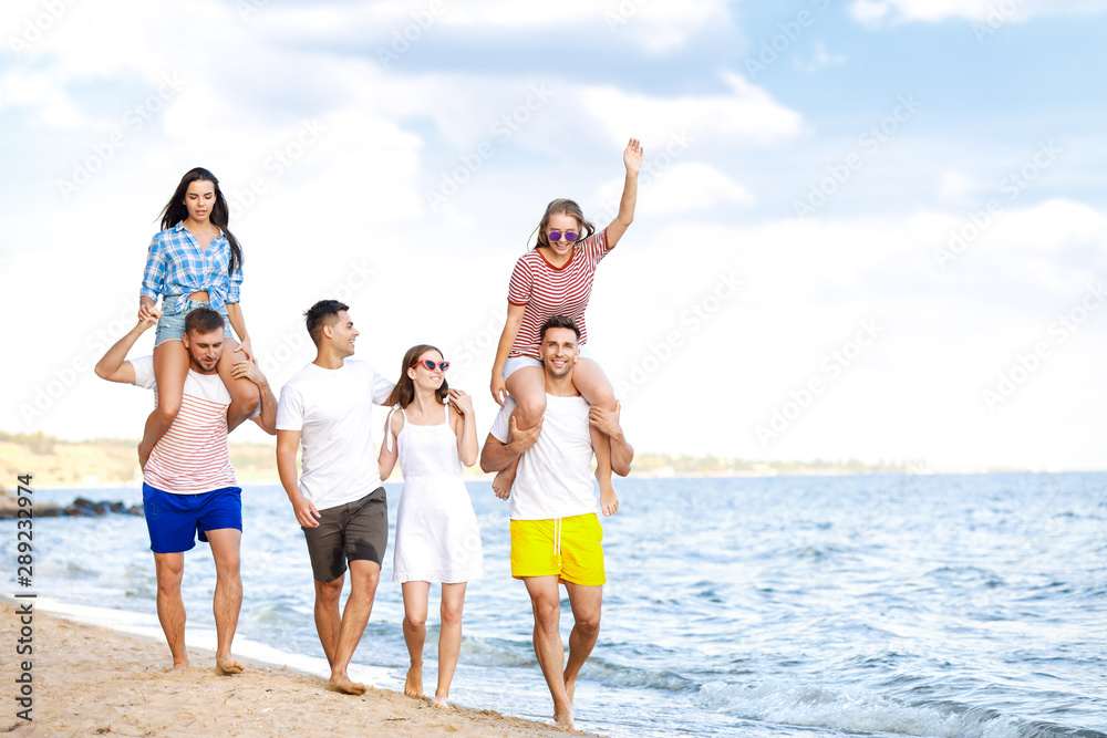 Happy friends on sea beach at resort