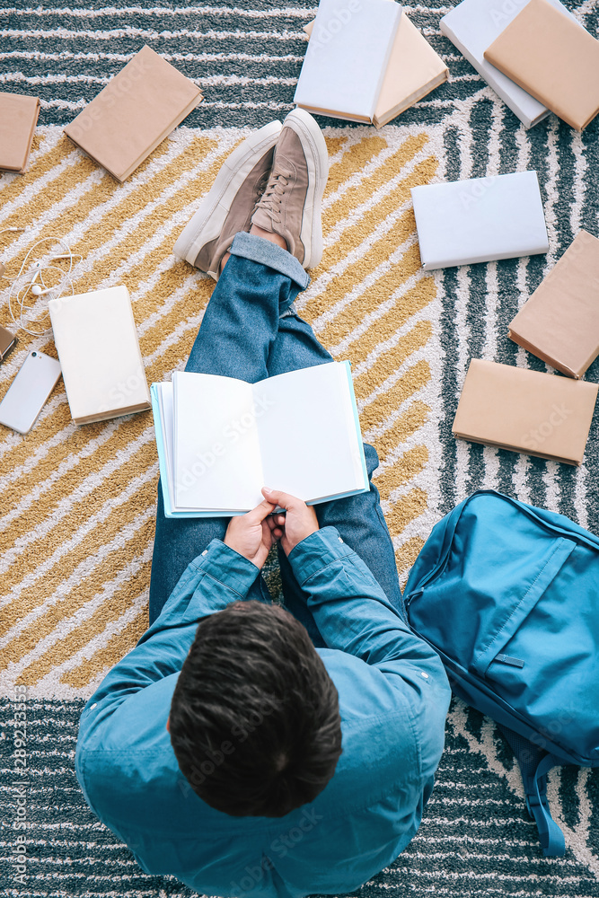 Asian student with a lot of books preparing for exam at home