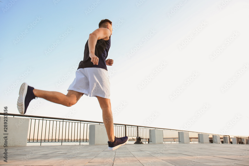 Handsome sporty man running outdoors