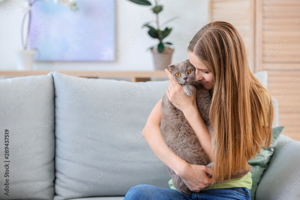 Beautiful woman with cute cat at home