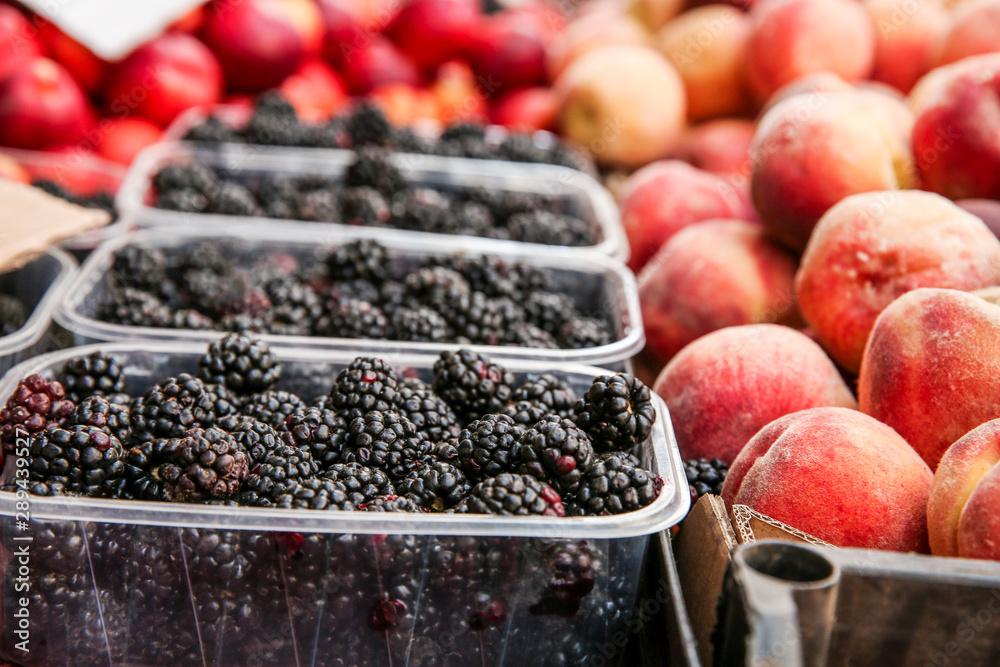 Fresh peaches and blackberries on counter at market