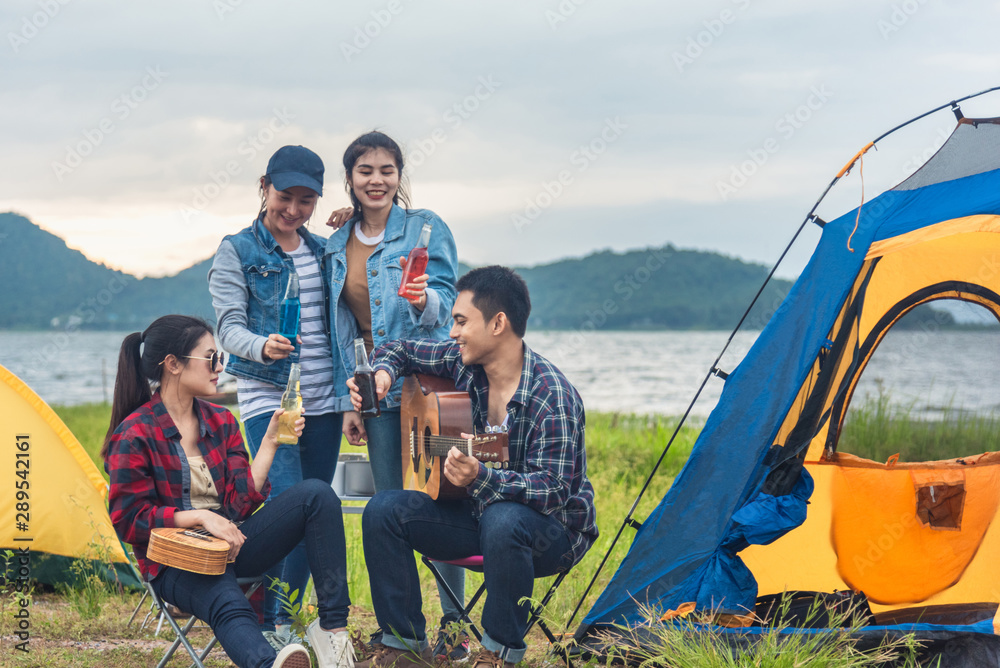 Group of backpackers relaxing near campfire, tourist background.