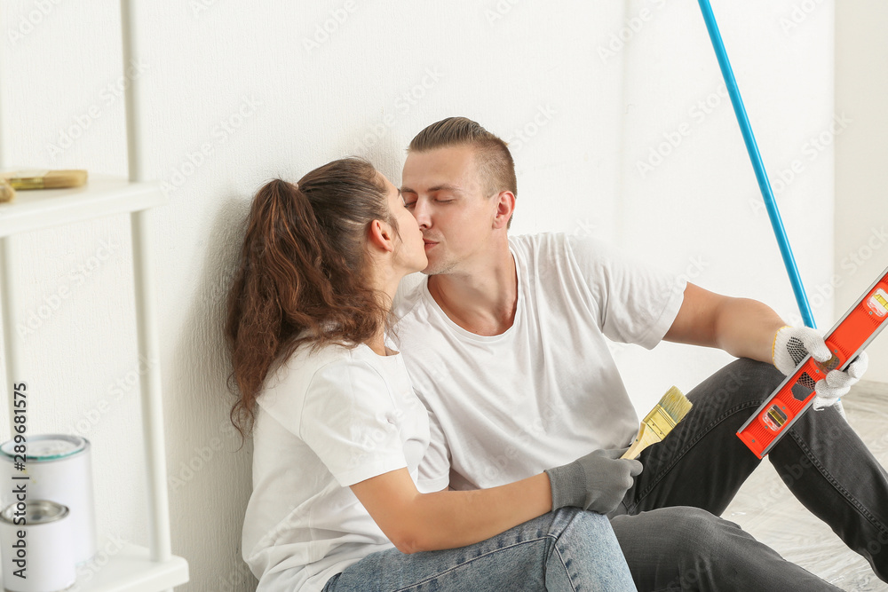 Kissing young couple resting during repair of their new house