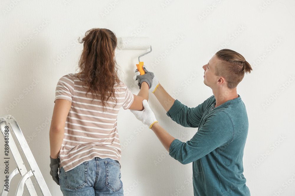 Happy young couple doing repair in their new house