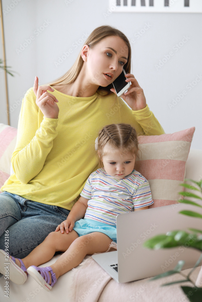 Working mother with her daughter at home