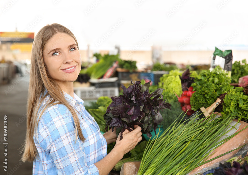 女人在市场上挑选新鲜草药