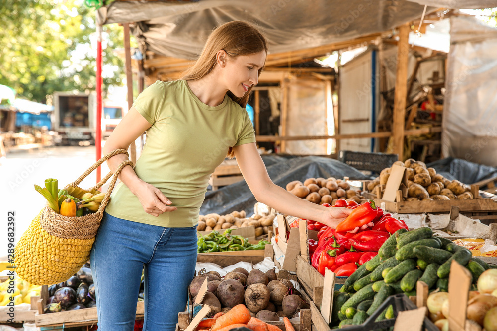 Woman choosing vegetables at market