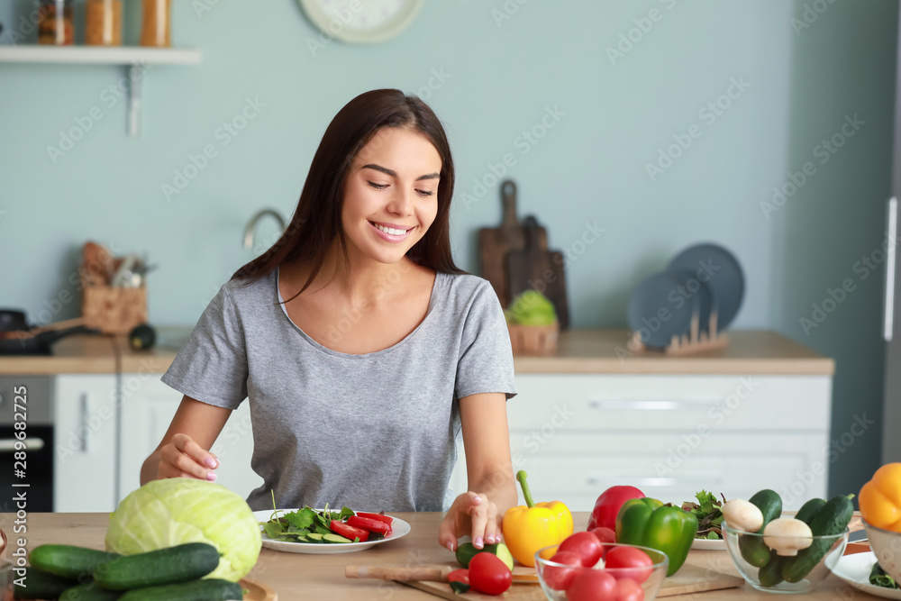 美丽的年轻女人在厨房做饭