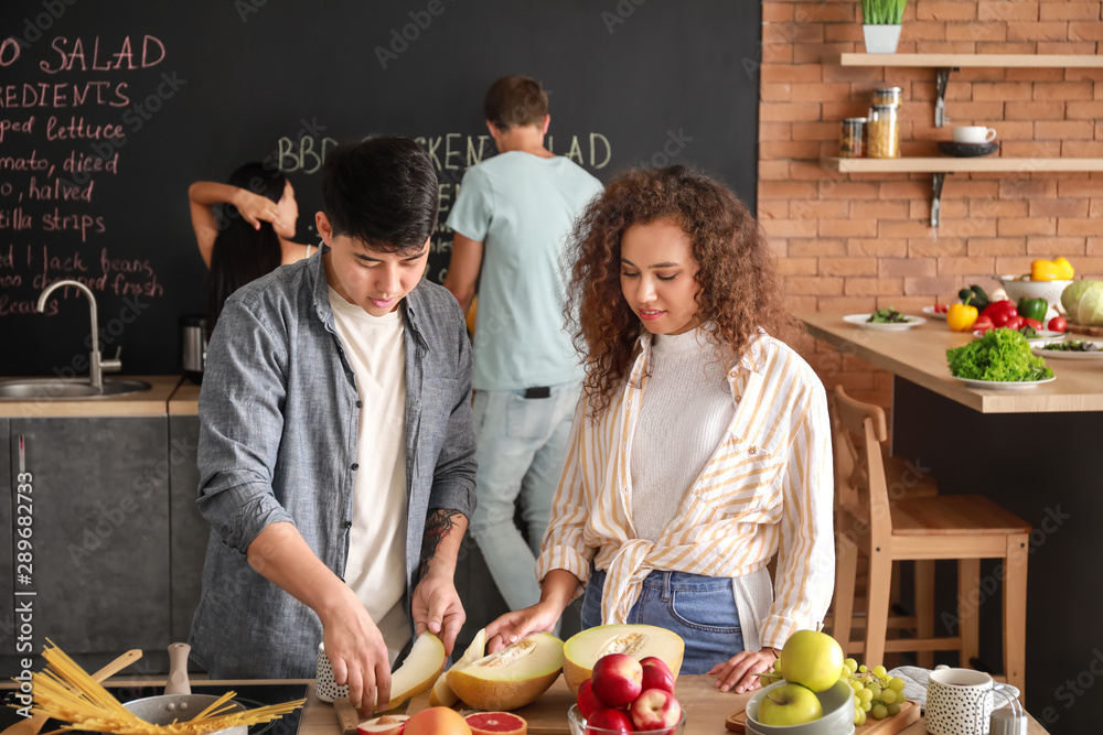 Happy couple cooking together in kitchen