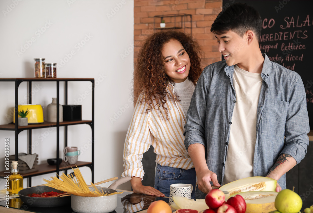 Happy couple cooking together in kitchen