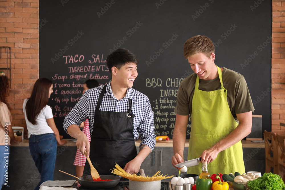 Handsome men cooking together in kitchen