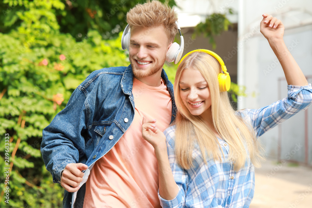 Young couple listening to music outdoors