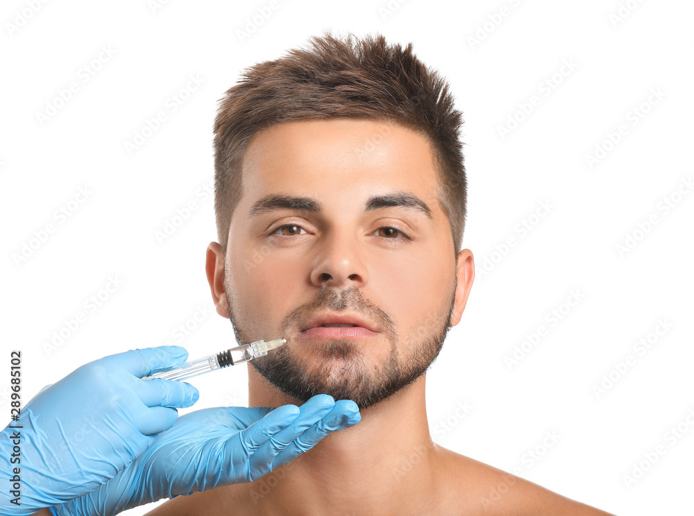 Handsome man receiving filler injection on white background