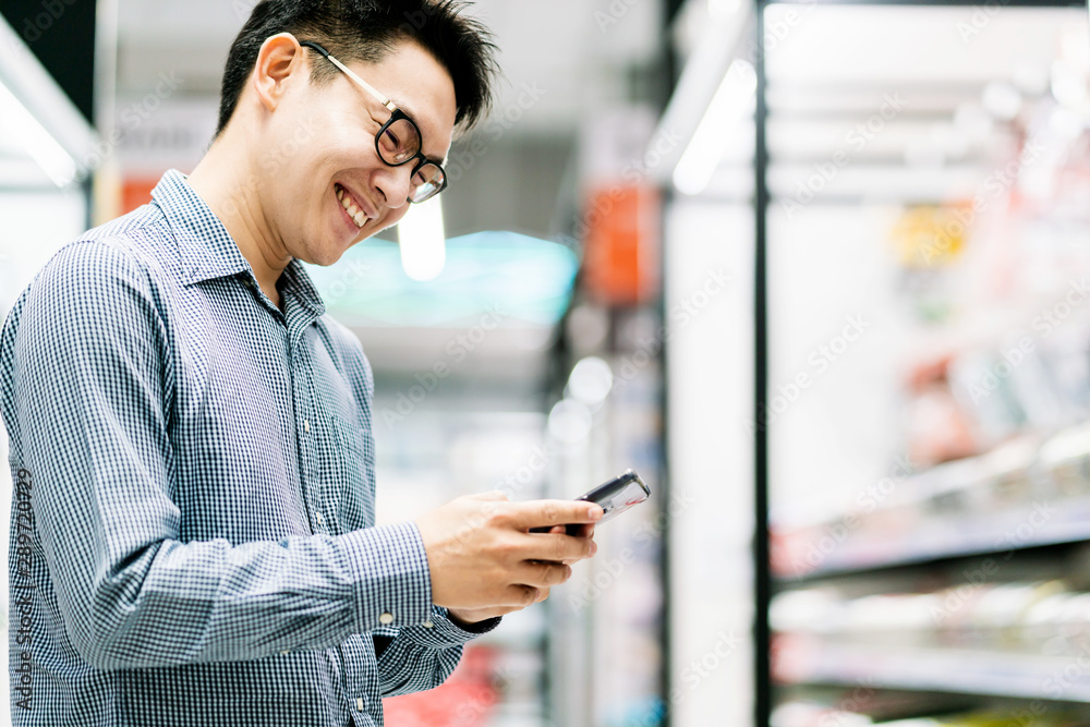 asian customer male shopping choose product from shelf in store mall background