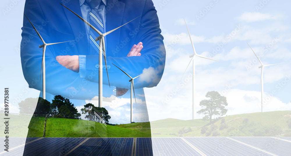 Double exposure graphic of business people working over wind turbine farm and green renewable energy