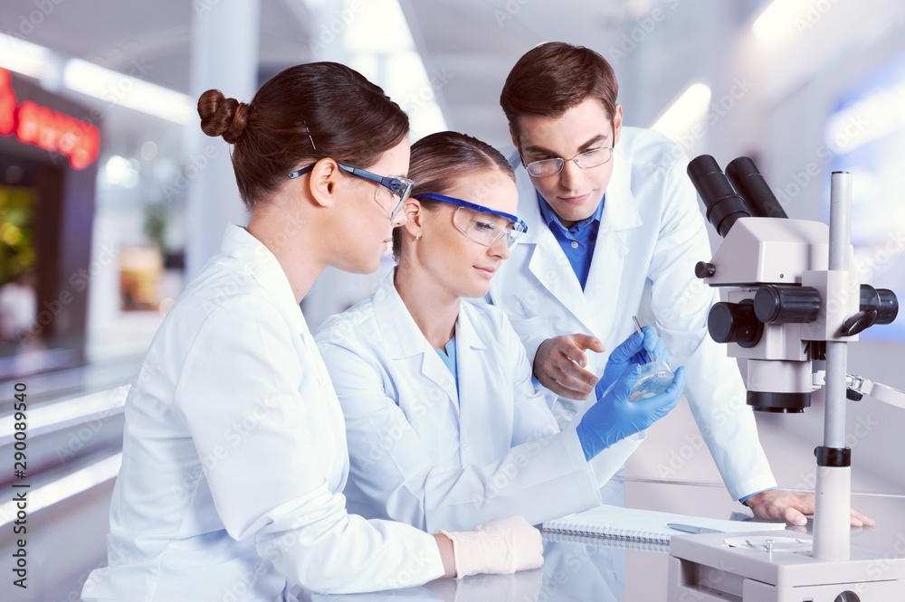 Female and male scientists in glasses working with microscope